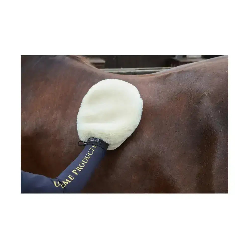 Cream-colored plush sheepskin fur perfection mitt with navy blue handle and gold lettering for super-soft deluxe grooming