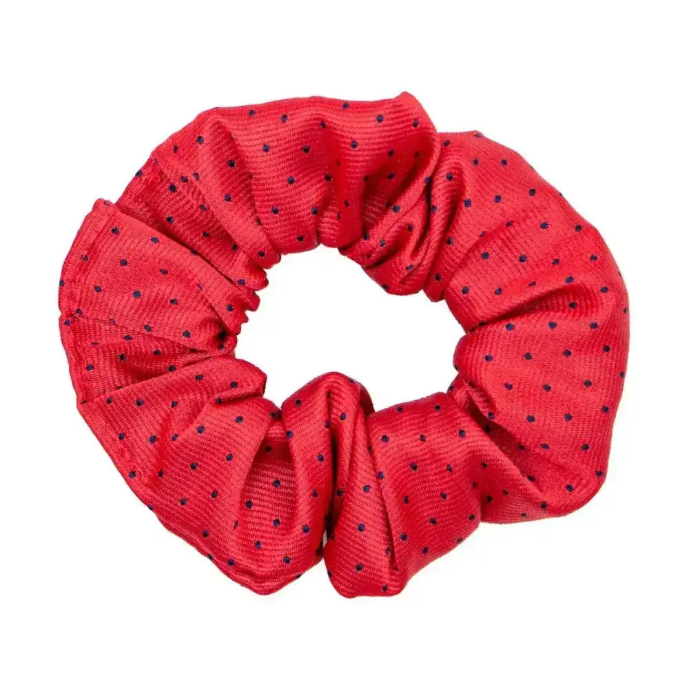 A vibrant red fabric hair scrunchie with subtle black polka dots perfect for the final touch to ring attire