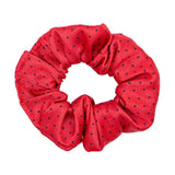 A vibrant red fabric hair scrunchie with subtle black polka dots perfect for the final touch to ring attire