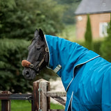 A black horse wearing a turquoise swish 100g detachable neck turnout rug with white trim and reflective strips