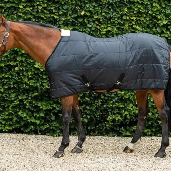 Black quilted swish 100g horse rug with adjustable cross surcingles and white tag on the neck for stable use