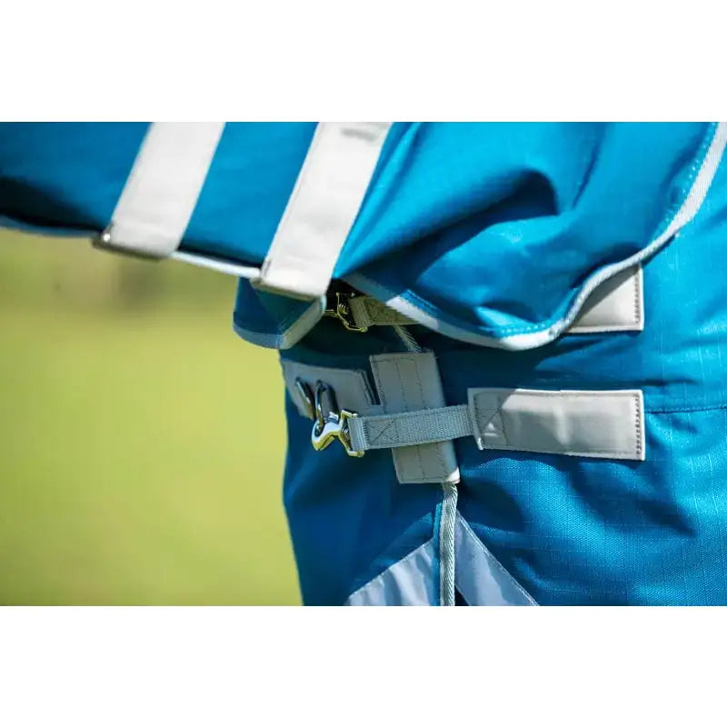 Turquoise 300g turnout rug with detachable neck features white reflective strips and gray adjustable straps on back side