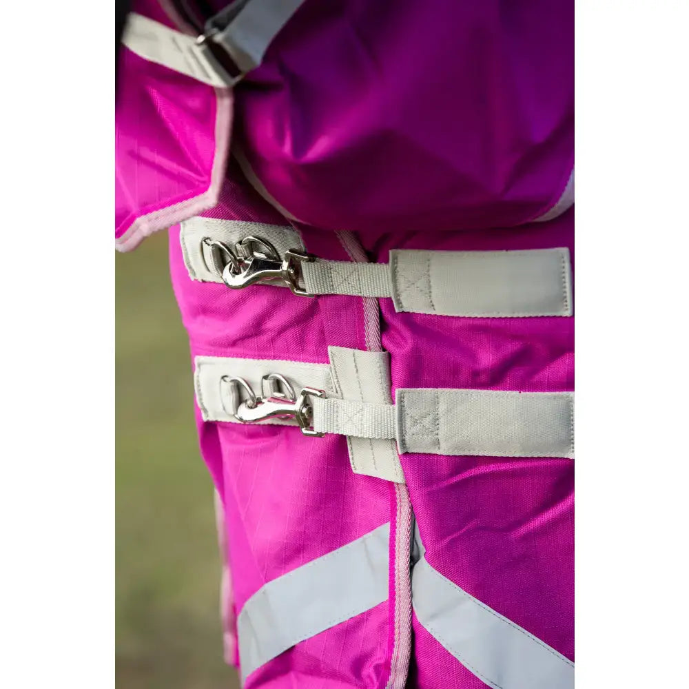 Bright pink swish 450g ultimate fixed neck turnout rug with reflective stripes and beige straps featuring metallic buckles