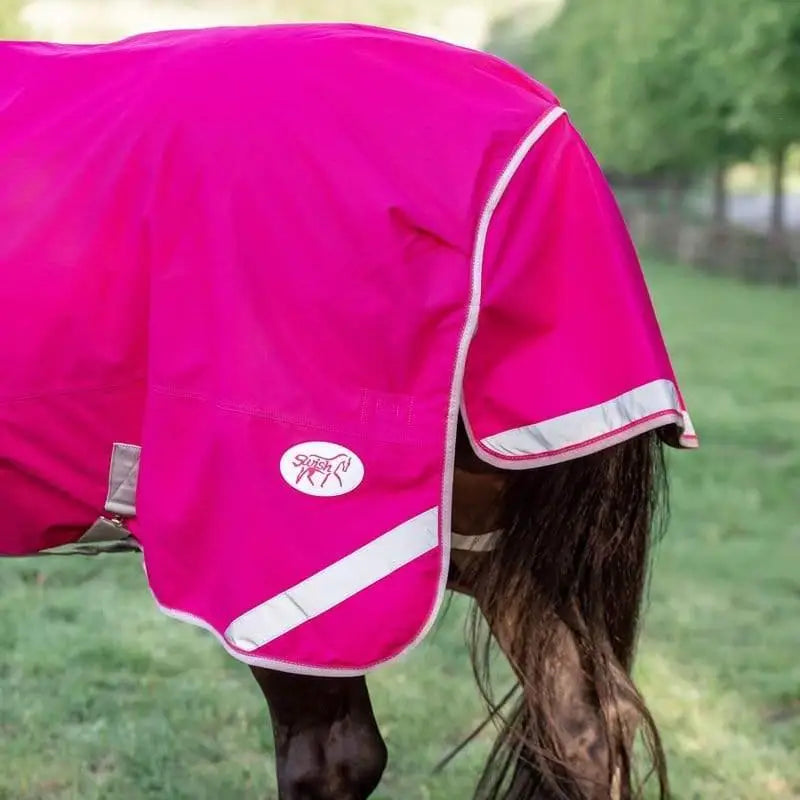 Vibrant pink turnout rug with detachable neck and neck cover included featuring white reflective trim and logo patch