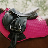 A black leather contact gp saddle sits on a pink quilted pad with wicking properties and high wither design