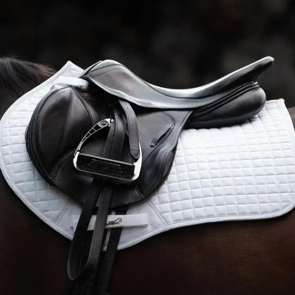 Black leather dressage saddle with silver stirrup iron on swish close contact gp saddle pad white with wicking properties