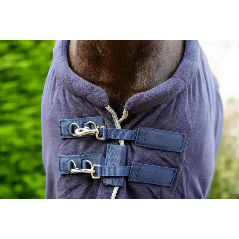 Navy blue quilted fleece horse rug with breathable cross surcingles and silver piping featuring adjustable straps and buckles