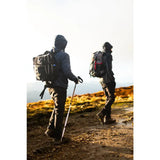A person wearing the back side of a water resistant 35l btactical backpack black smoke with red accent straps