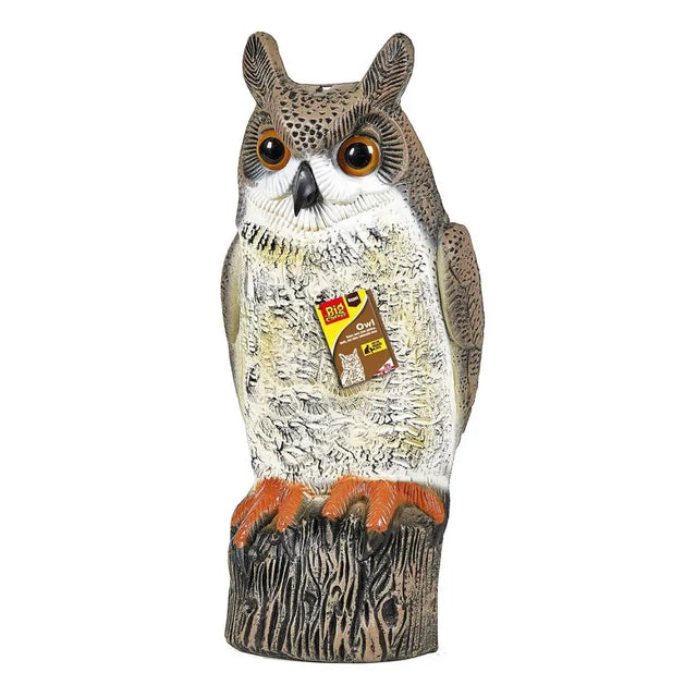 A realistic big cheese owl decoy with detailed brown and white feathers and orange talons on a tree stump base