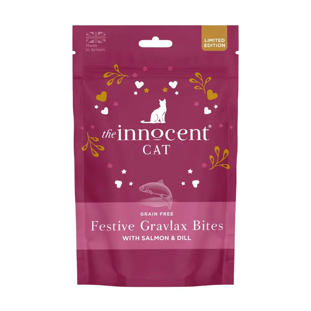 A vibrant magenta pouch of innocent cat festive grain free cat festive bites with white cat silhouette and gold leaf accents