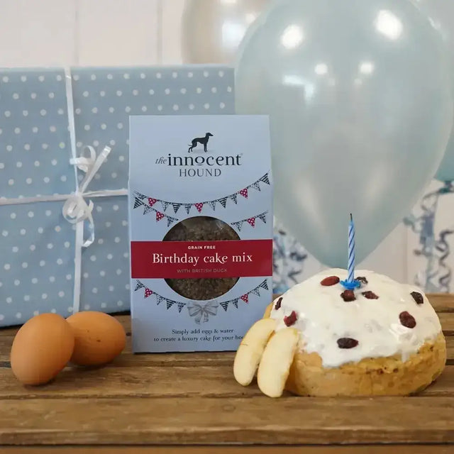 A white and red innocent hound birthday grain-free cake mix package with british duck and black dog logo