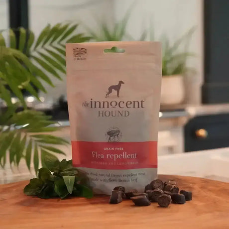 A beige and red pouch of the innocent hound flea repellent natural grain-free flea repellent treats with scattered pieces