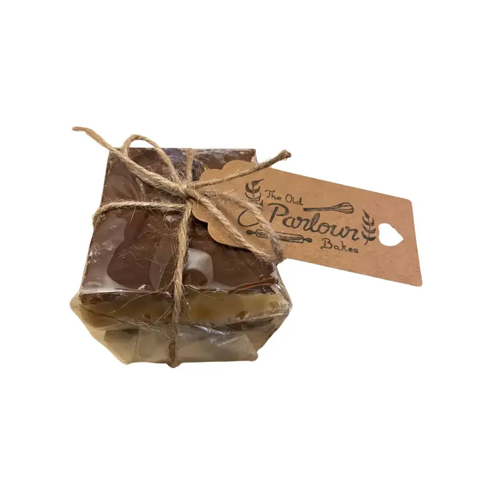A square caramel shortbread cake slice wrapped in clear cellophane with rustic twine from north devon