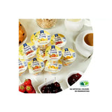 Yellow and white plastic containers of creamy yoghurt golden acre with strawberry cherry and mango labels for a fresh snack