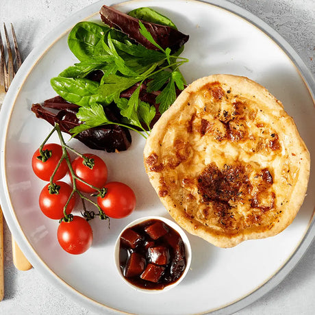 Golden-brown thorners mature cheddar and onion quiche with flaky crust served with fresh greens and cherry tomatoes