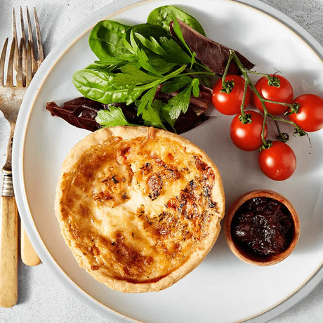 Golden brown thorners quiche lorraine with flaky crust served on white plate perfect with free range smokey bbq pork ribs