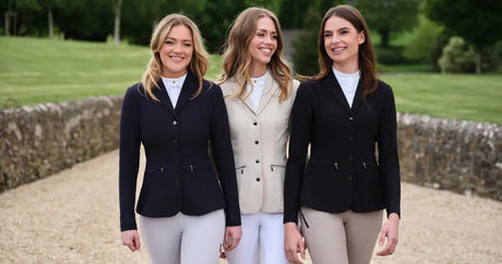 Three women in equestrian jackets, navy, beige, and black, with matching white collars and tailored fits.
