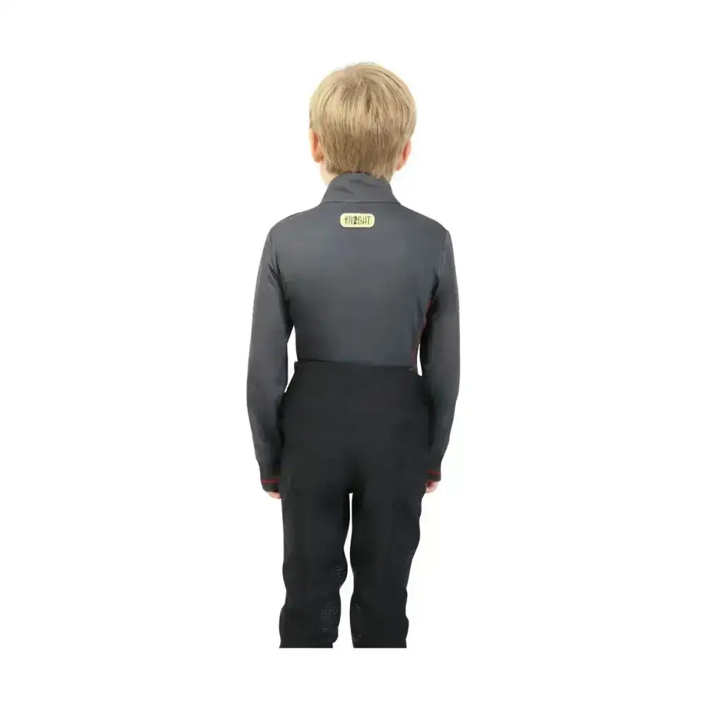 Back side of charcoal grey base layer jacket with small yellow label paired with black pants from tractor collection base by little knight