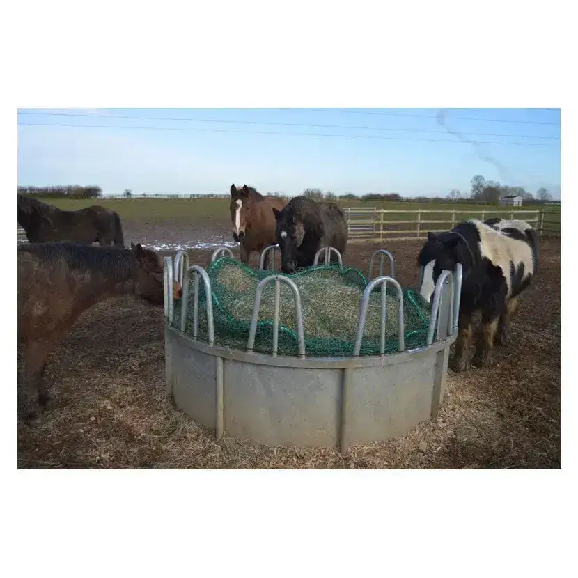 Gray metal horse feed trough with green mesh lining and curved handles featuring a trickle net topper unique design