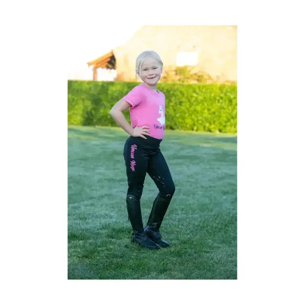 Pink unicorn magic t-shirt by little rider with fun unicorn design and pink script on black riding pants side