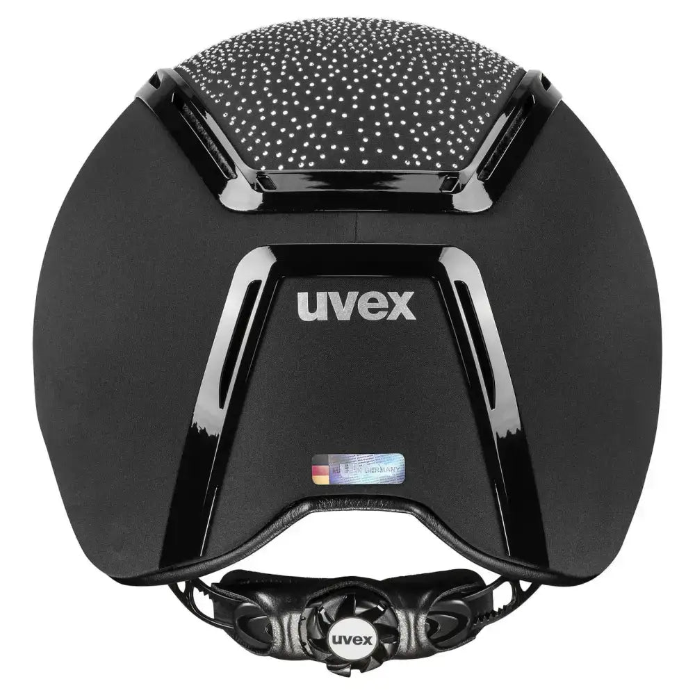Black uvex exxeed flash riding hat with glossy finish, textured top, sleek vents, and vegan leather details