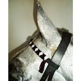 Silver horse statue wearing black leather bridle with decorative white and dark purple velvet browbands strap