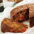 A rich golden-brown victorian fruit cake sidoli with dense interior filled with dark and red candied fruits