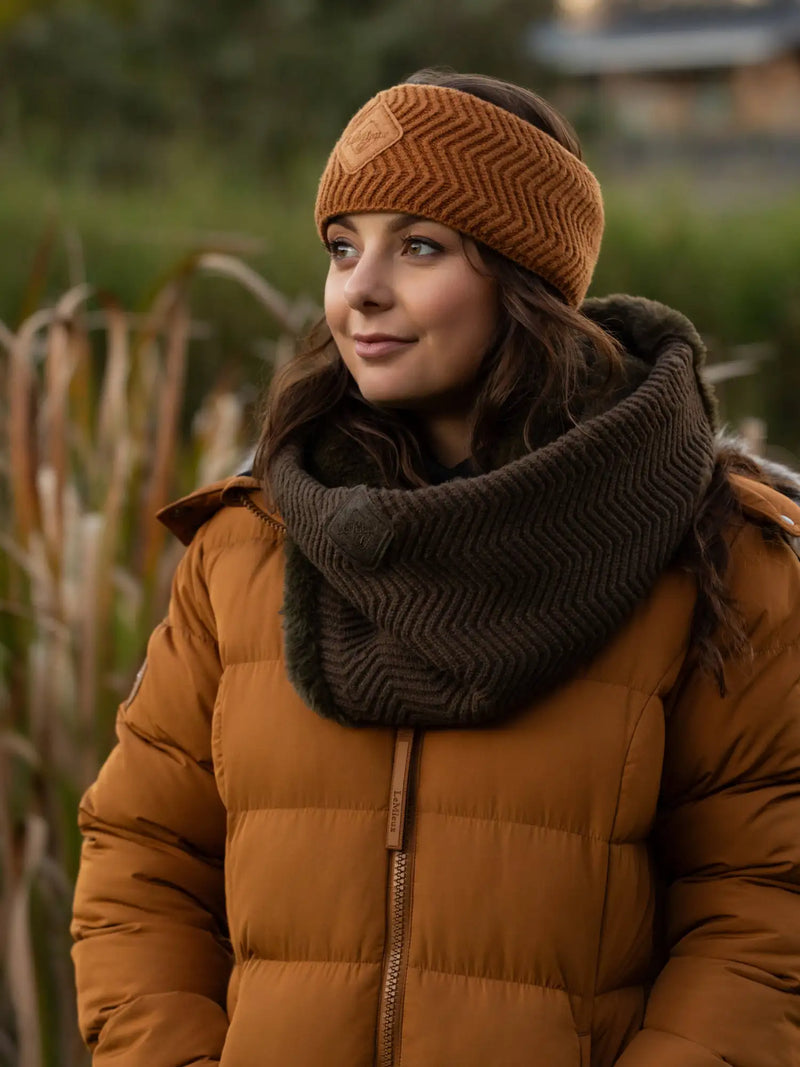 Warm brown knitted headband with a subtle herringbone pattern and a small leather patch on the front.