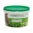 Green-lidded plastic tub of wendals garlic and fenugreek horse supplements with label showing brown horse and daisy field