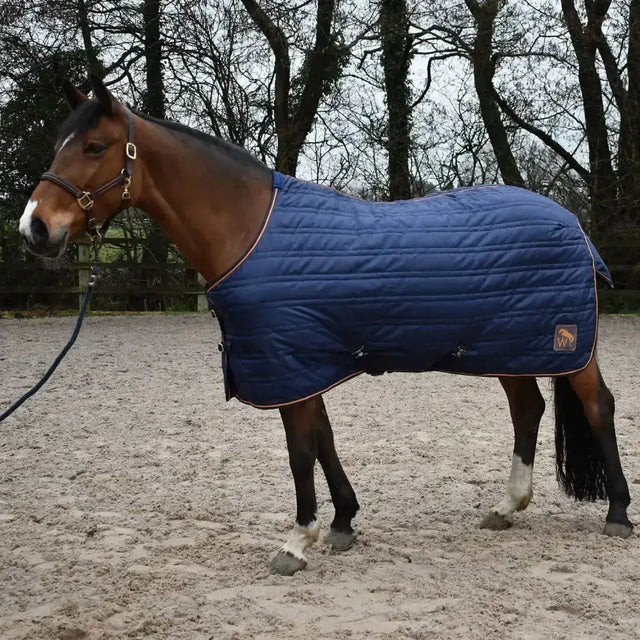 Navy blue quilted whitaker pippa stable rug 100gm with tan trim and logo patch perfect for horses in stable use