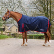 Chestnut horse wearing a navy whitaker r443 rastrick v2 100g turnout rug with red trim and white logo