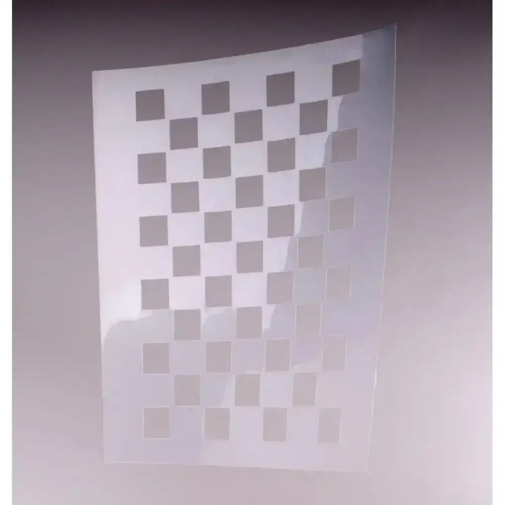 A translucent white plastic stencil with square cutouts for precise horse grooming called windsor quarter markers