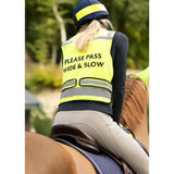 A bright yellow woof wear vis riding vest with black please pass wide and slow text silver stripes and zipped pockets worn by rider