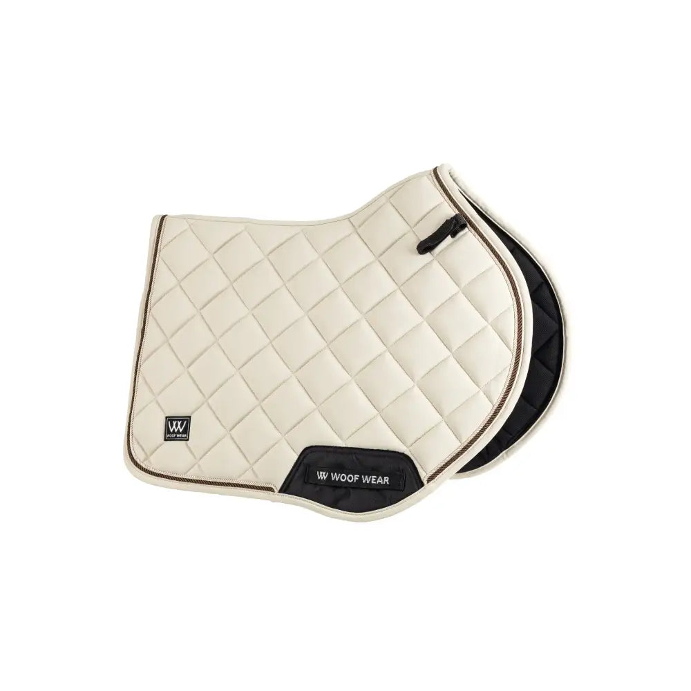 Cream-colored quilted vision aura close contact saddle pad with black trim and w woof wear logo panel