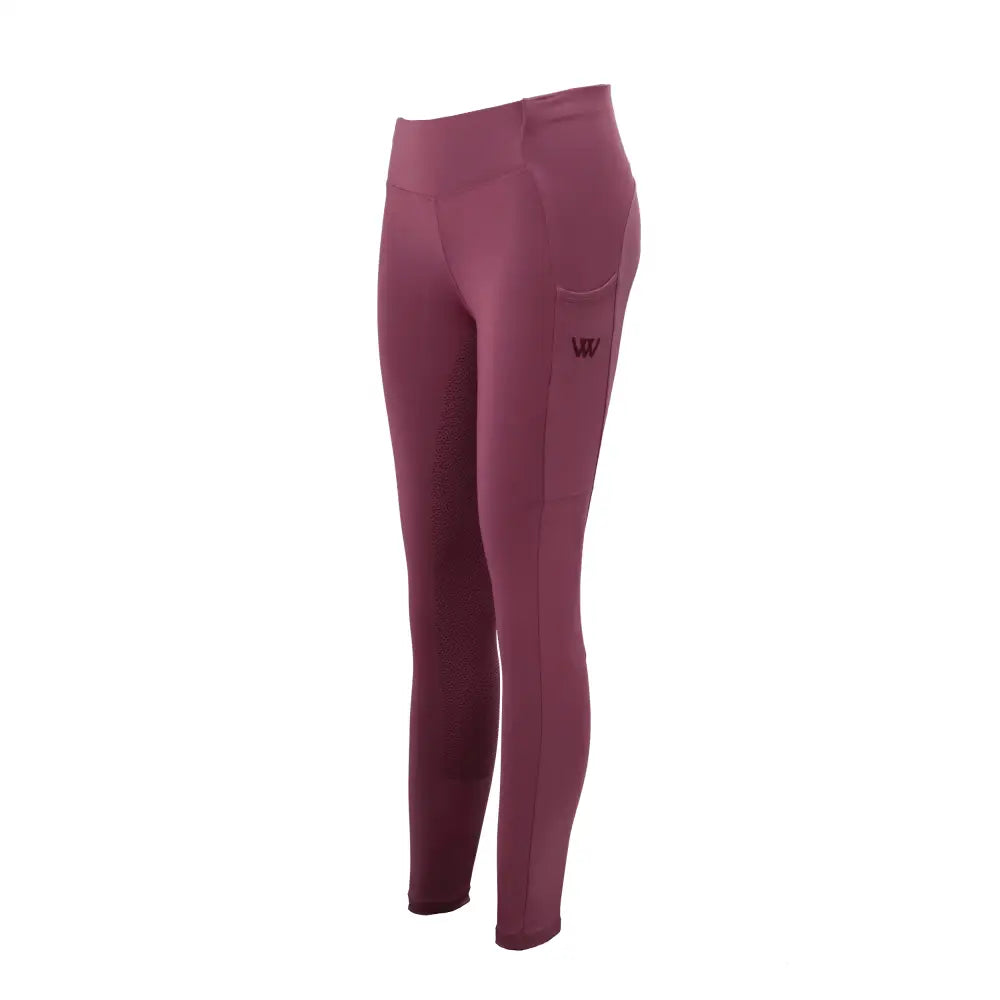 A pair of woof wear young rider pro tights in dusty rose with high waist and subtle side pocket featuring logo
