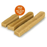 Three beige bone-shaped yakers original dog treats made from yak milk on a dark green tray for chewing fun