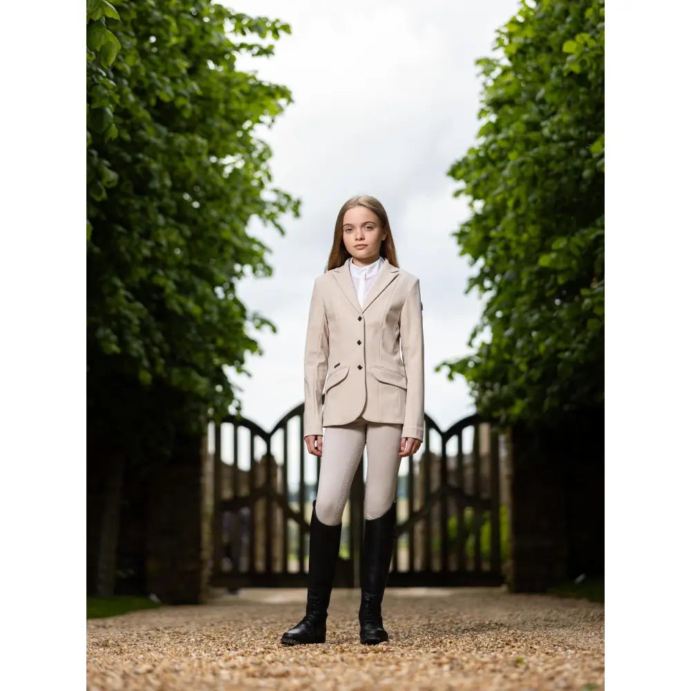 Beige lemieux young rider kennedy show jacket stone with three black buttons and flap pockets for equestrian use