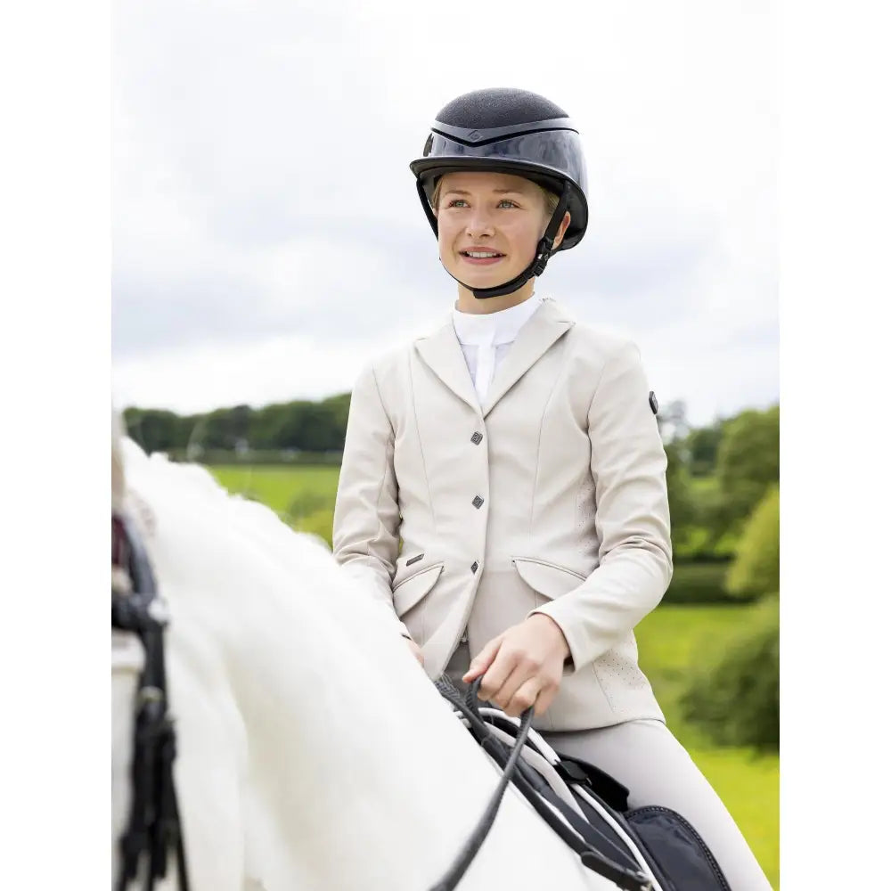 Young rider kennedy show jacket stone paired with black lemieux equestrian helmet with glossy finish for horses